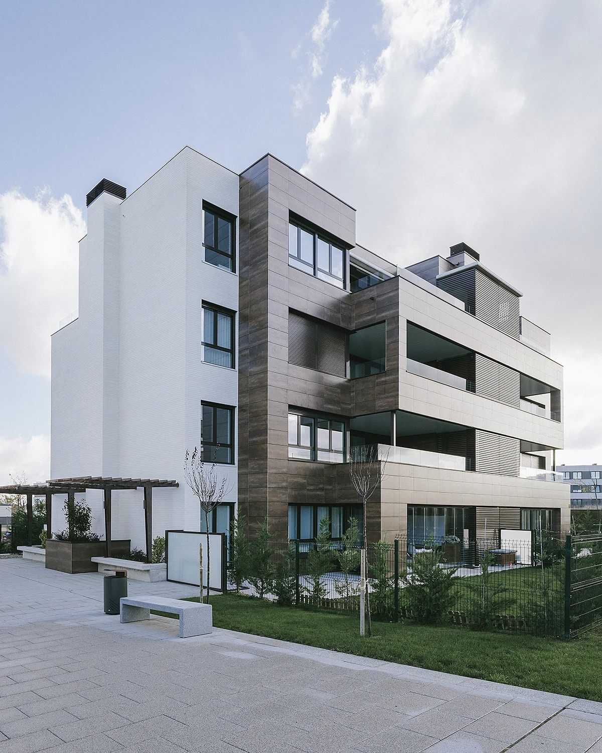 Fotografía frontal de la fachada ventiladas de color blanco y marrón de un edificio de 4 plantas. Reforma integral de edificios en Vitoria-Gasteiz